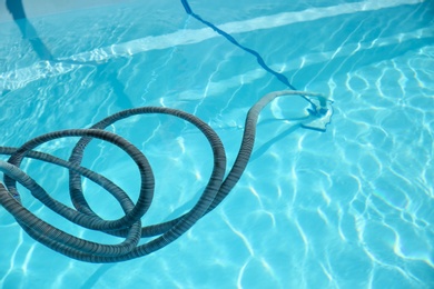 Cleaning outdoor swimming pool with underwater vacuum