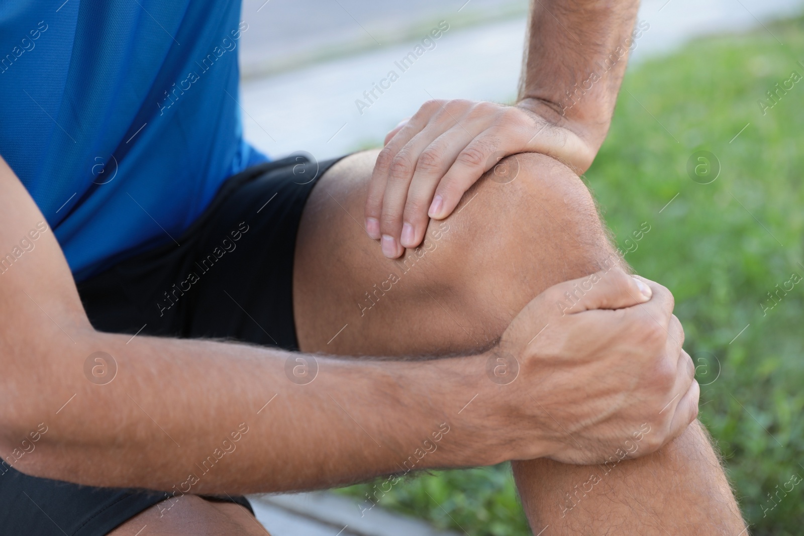 Photo of Man in sportswear having knee problems outdoors, closeup