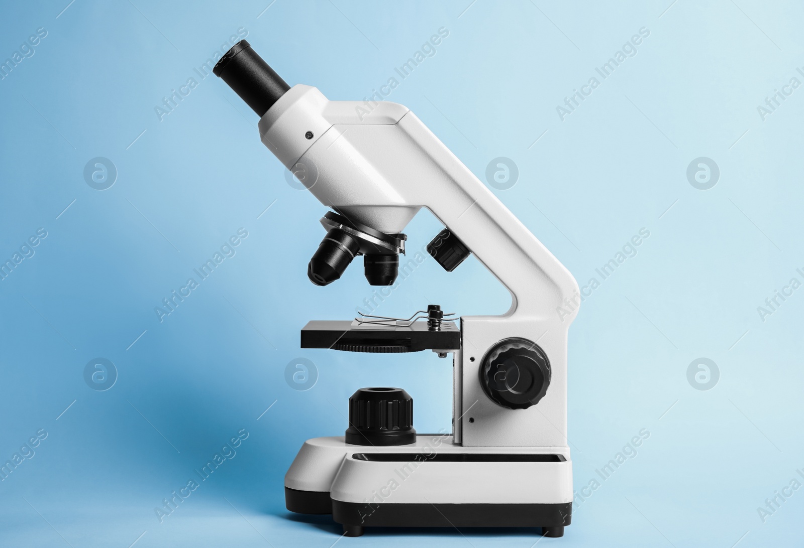 Photo of Modern microscope on blue background. Medical equipment