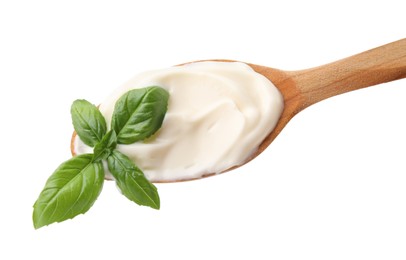 Wooden spoon with tasty mayonnaise and basil isolated on white