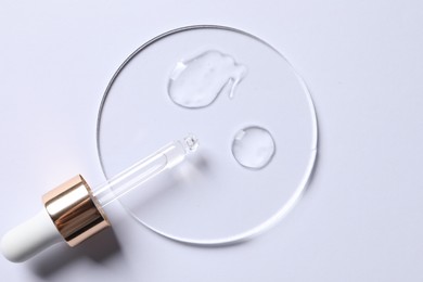 Photo of Samples of cosmetic serum and pipette on white background, top view