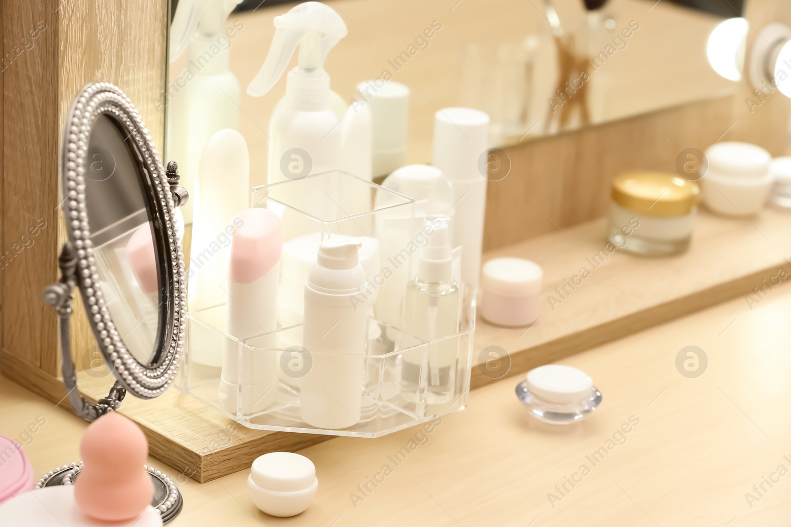 Photo of Organizer with cosmetic products on dressing table indoors