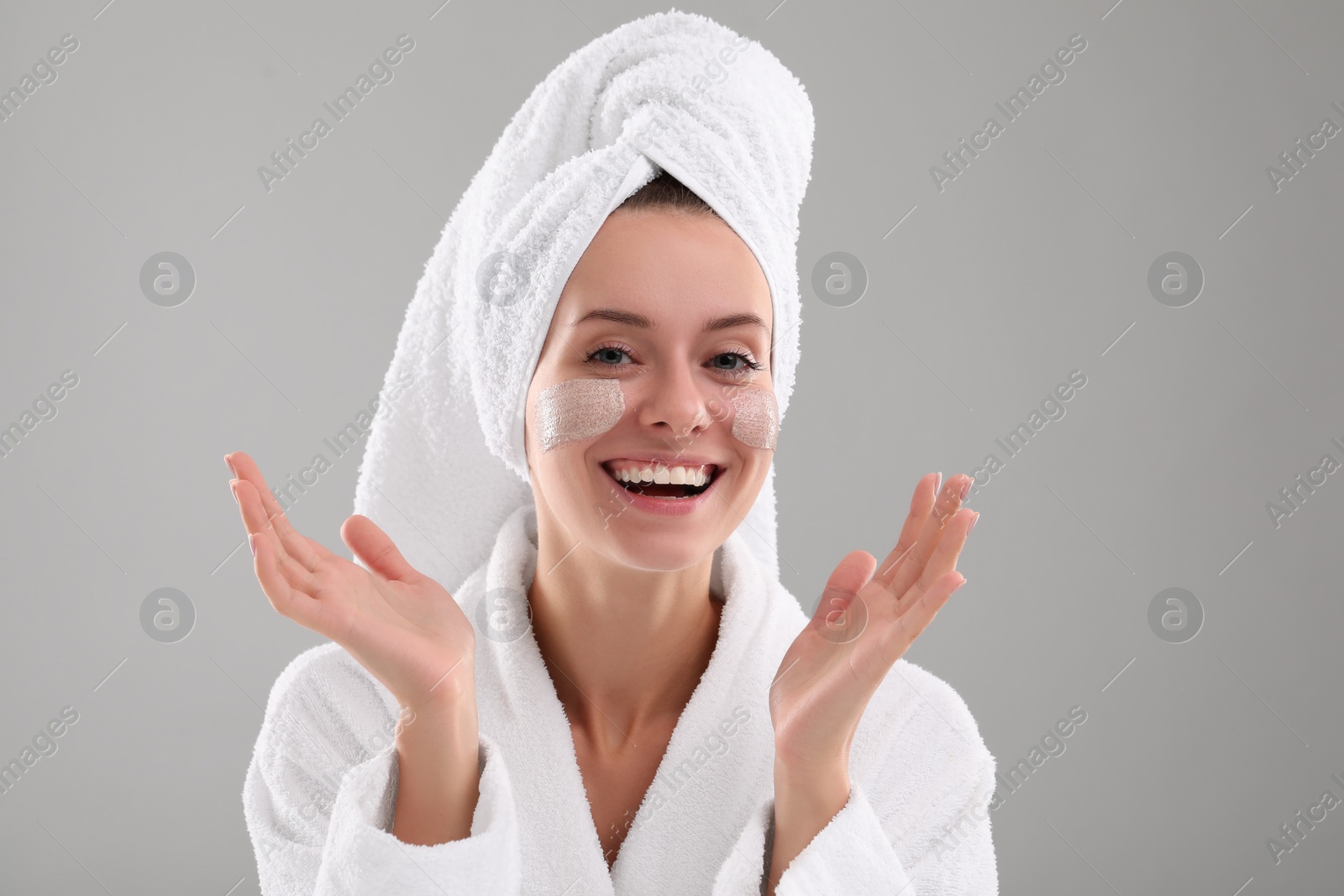 Photo of Woman with cosmetic product on her face against grey background. Spa treatments