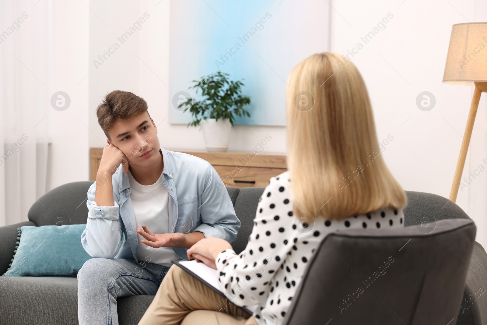 Photo of Psychologist working with teenage boy in office