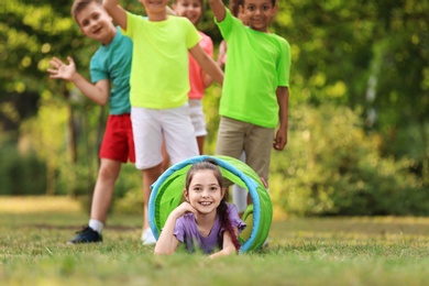 Cute little child playing with friends in park