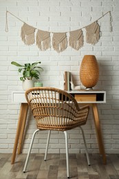 Photo of Cozy room interior with desk and stylish macrame on wall