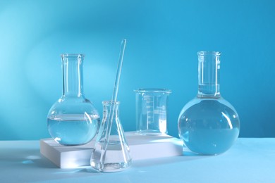 Photo of Laboratory analysis. Different glassware on table against light blue background