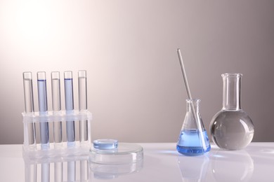 Laboratory analysis. Different glassware on table against light background