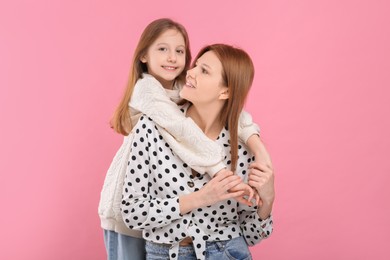 Photo of Portrait of happy mother and her cute daughter on pink background