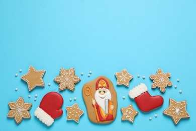 Tasty gingerbread cookies on light blue background, flat lay with space for text. St. Nicholas Day celebration