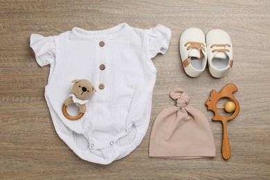 Photo of Flat lay composition with baby clothes and accessories on wooden table