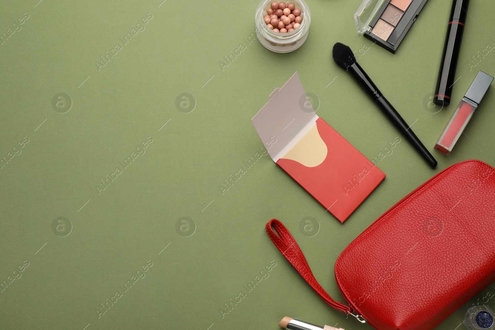 Photo of Flat lay composition with facial oil blotting tissues and makeup products on green background, space for text. Mattifying wipes