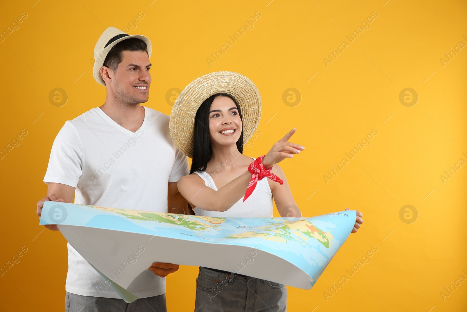 Photo of Couple of tourists with map on yellow background