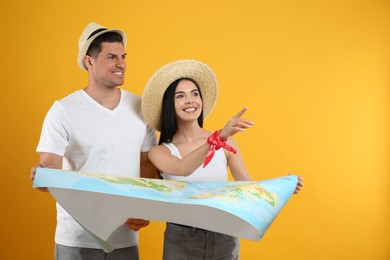 Photo of Couple of tourists with map on yellow background