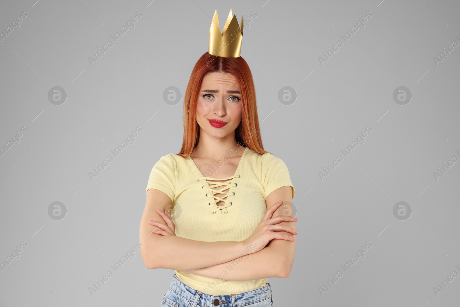 Photo of Emotional young woman with princess crown on light grey background