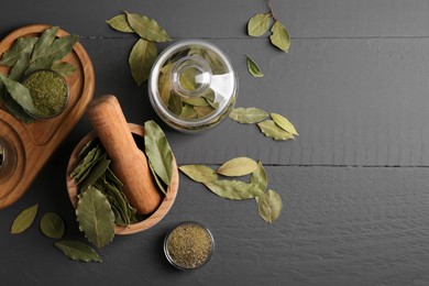 Photo of Whole and ground bay leaves on grey wooden table, flat lay. Space for text