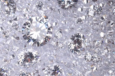 Photo of Many beautiful shiny diamonds as background, top view