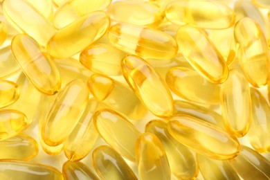 Photo of Yellow vitamin capsules as background, top view