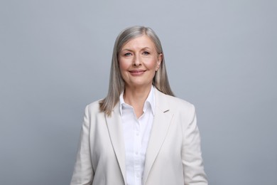 Portrait of beautiful senior woman on grey background