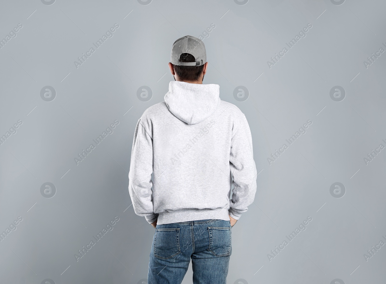 Photo of Young man in sweater on grey background. Mock up for design