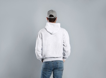 Young man in sweater on grey background. Mock up for design