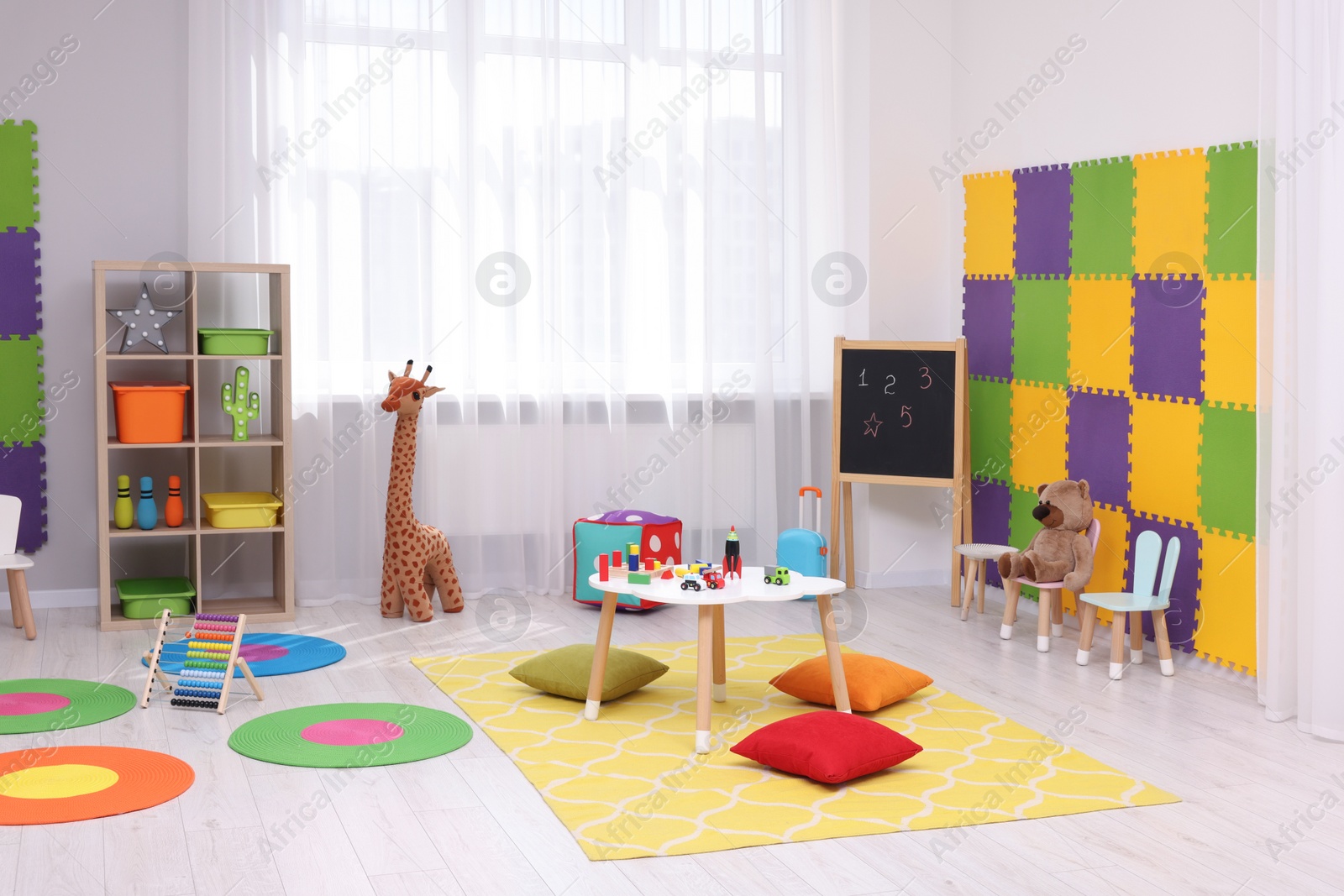 Photo of Child`s playroom with different toys and furniture. Cozy kindergarten interior