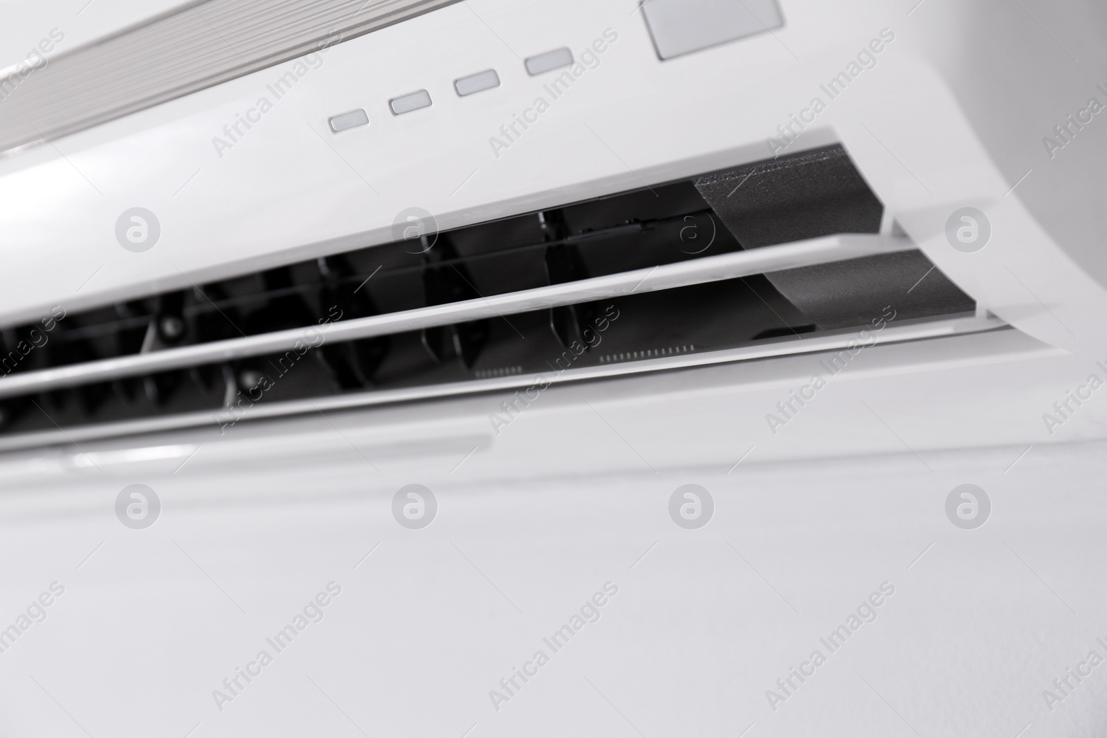 Photo of Modern air conditioner on white wall indoors, closeup view