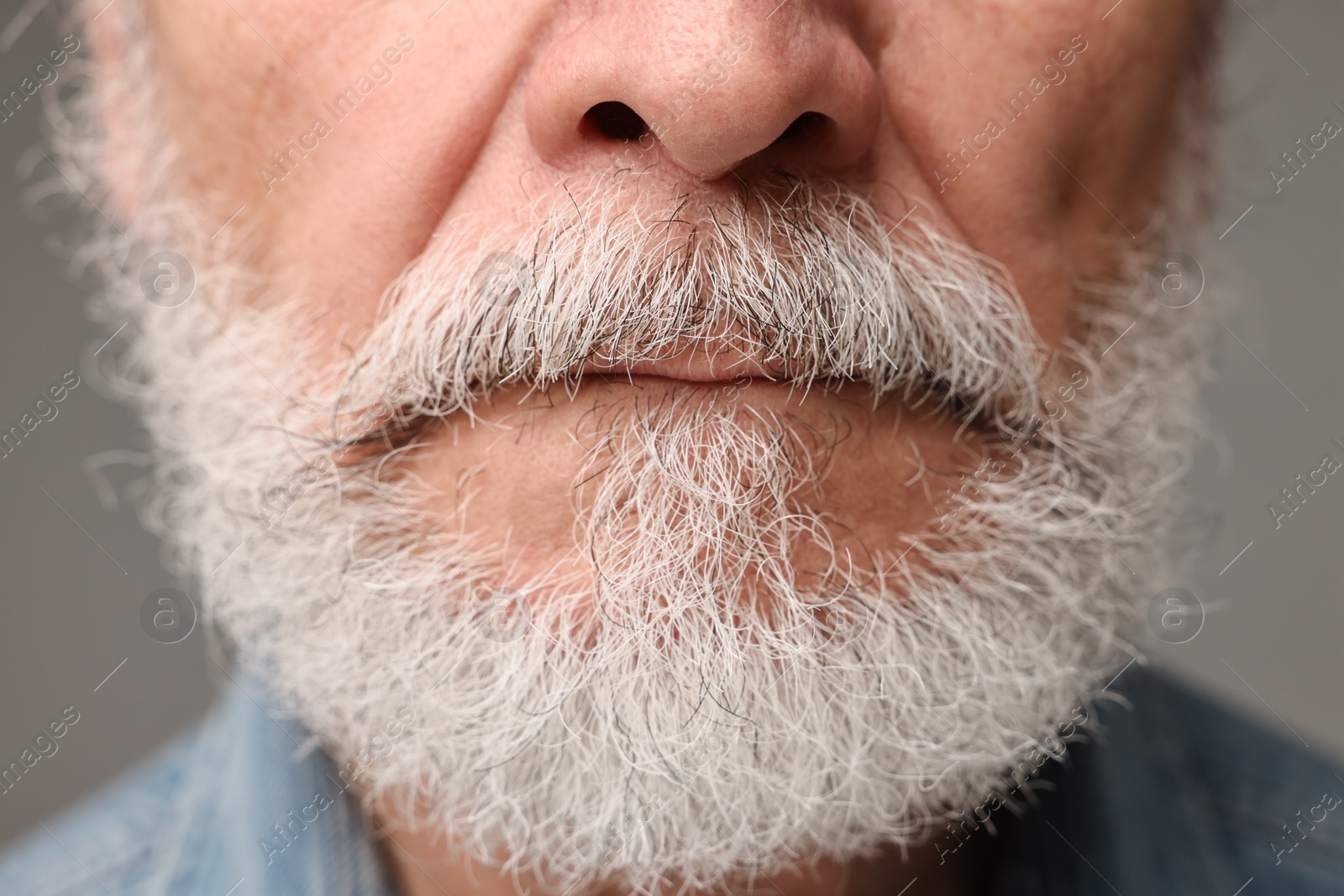 Photo of Man with mustache on grey background, closeup