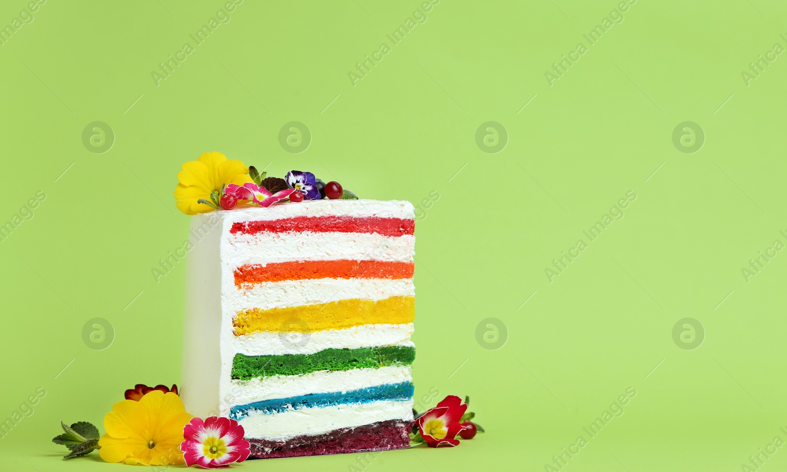 Photo of Slice of delicious rainbow cake with flowers on color background