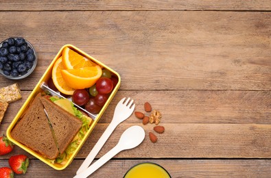 Photo of Flat lay composition with lunch box and tasty healthy food on wooden table, space for text. School dinner