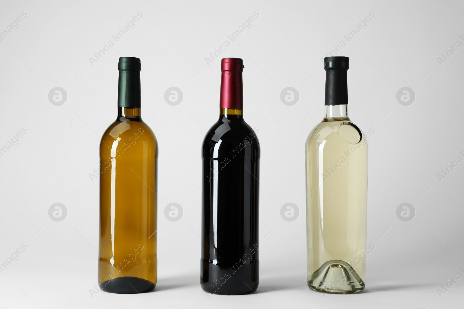 Photo of Bottles with different types of wine on light background