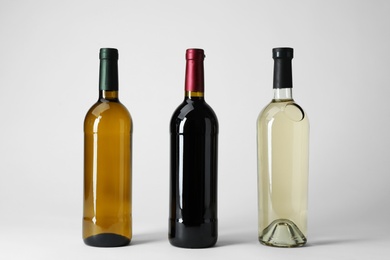 Photo of Bottles with different types of wine on light background