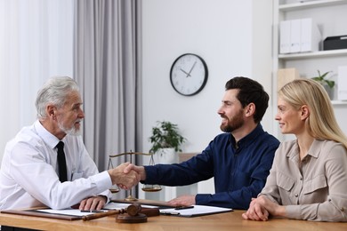 Lawyer shaking hands with clients in office