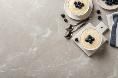 Delicious semolina pudding with blueberries on marble table, flat lay. Space for text