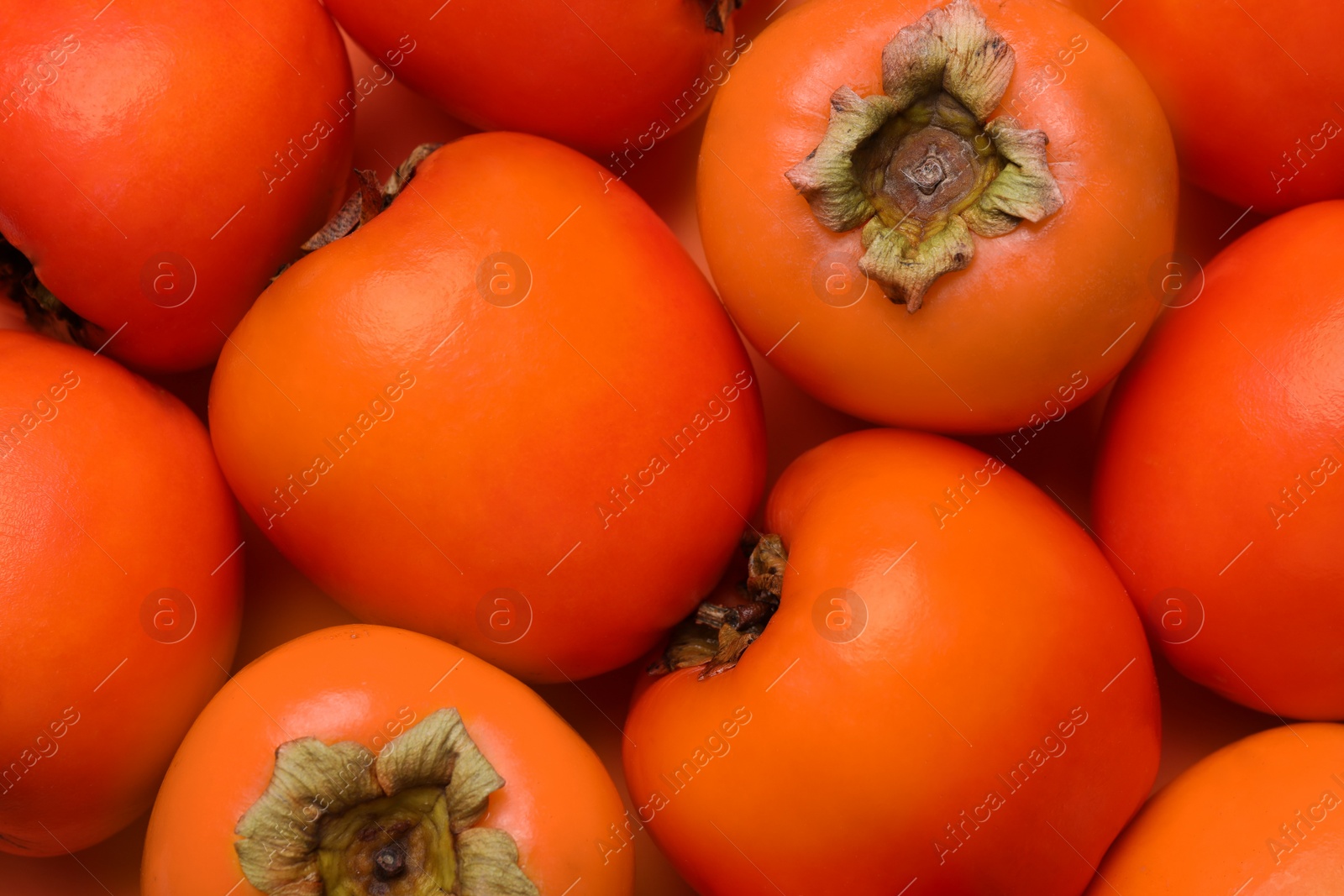 Photo of Delicious ripe juicy persimmons as background, top view