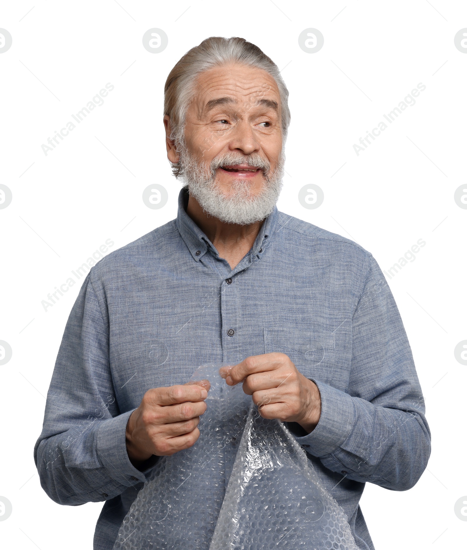 Photo of Happy senior man popping bubble wrap on white background. Stress relief