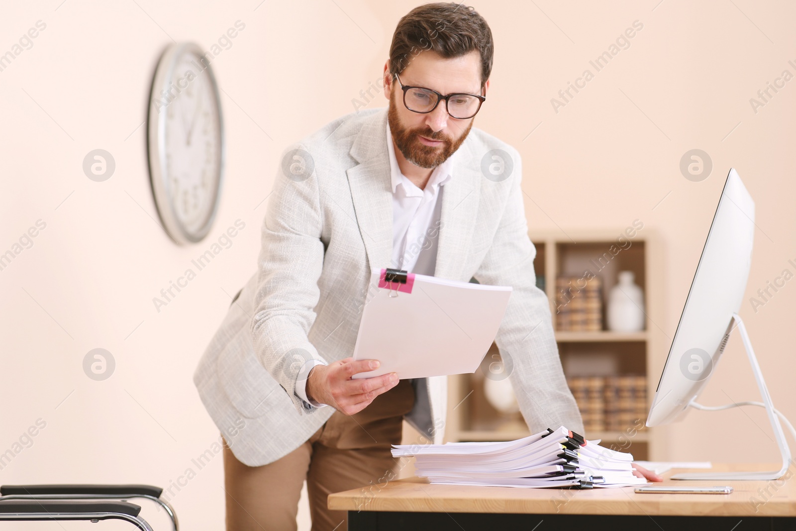 Photo of Businessman working with documents at wooden table in office