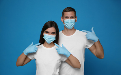 Volunteers in masks and gloves on blue background. Protective measures during coronavirus quarantine