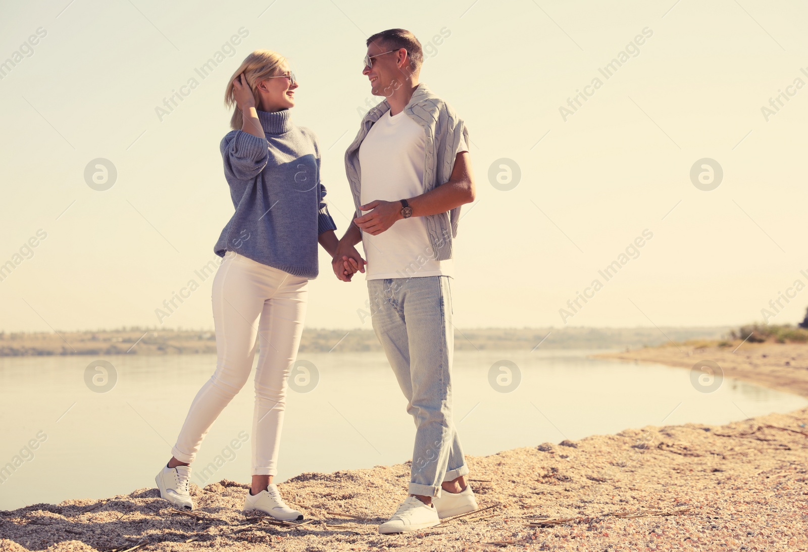 Photo of Happy couple in stylish sweaters on beach