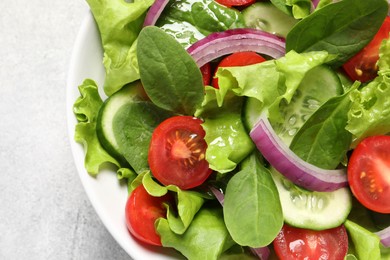 Photo of Delicious vegetable salad on light grey table, top view. Space for text