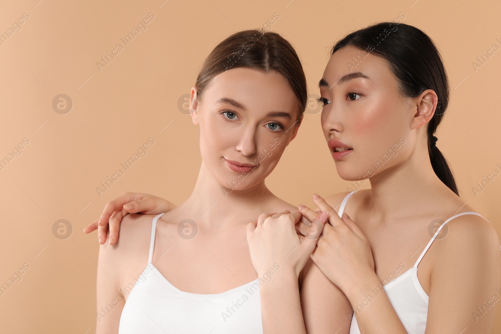 Photo of Beautiful young women with healthy skin on beige background