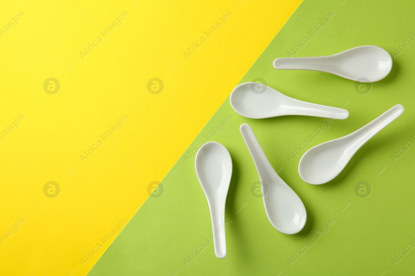 Photo of Miso soup spoons on color background, flat lay. Space for text