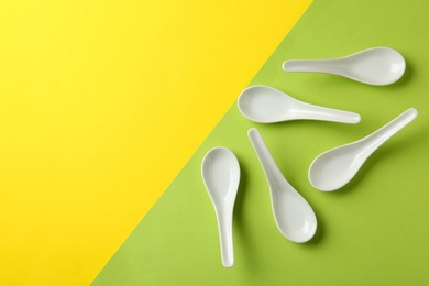 Miso soup spoons on color background, flat lay. Space for text