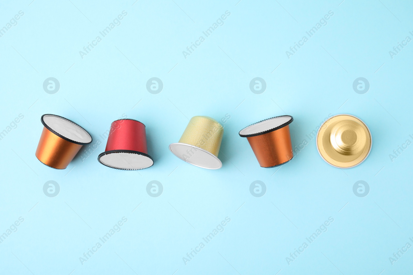 Photo of Many coffee capsules on light blue background, flat lay