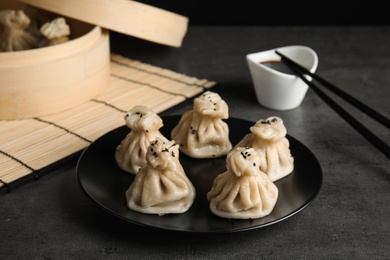 Plate with tasty baozi dumplings on table