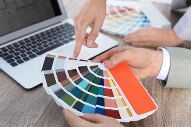Photo of Team of designers working with color palette at office table, closeup