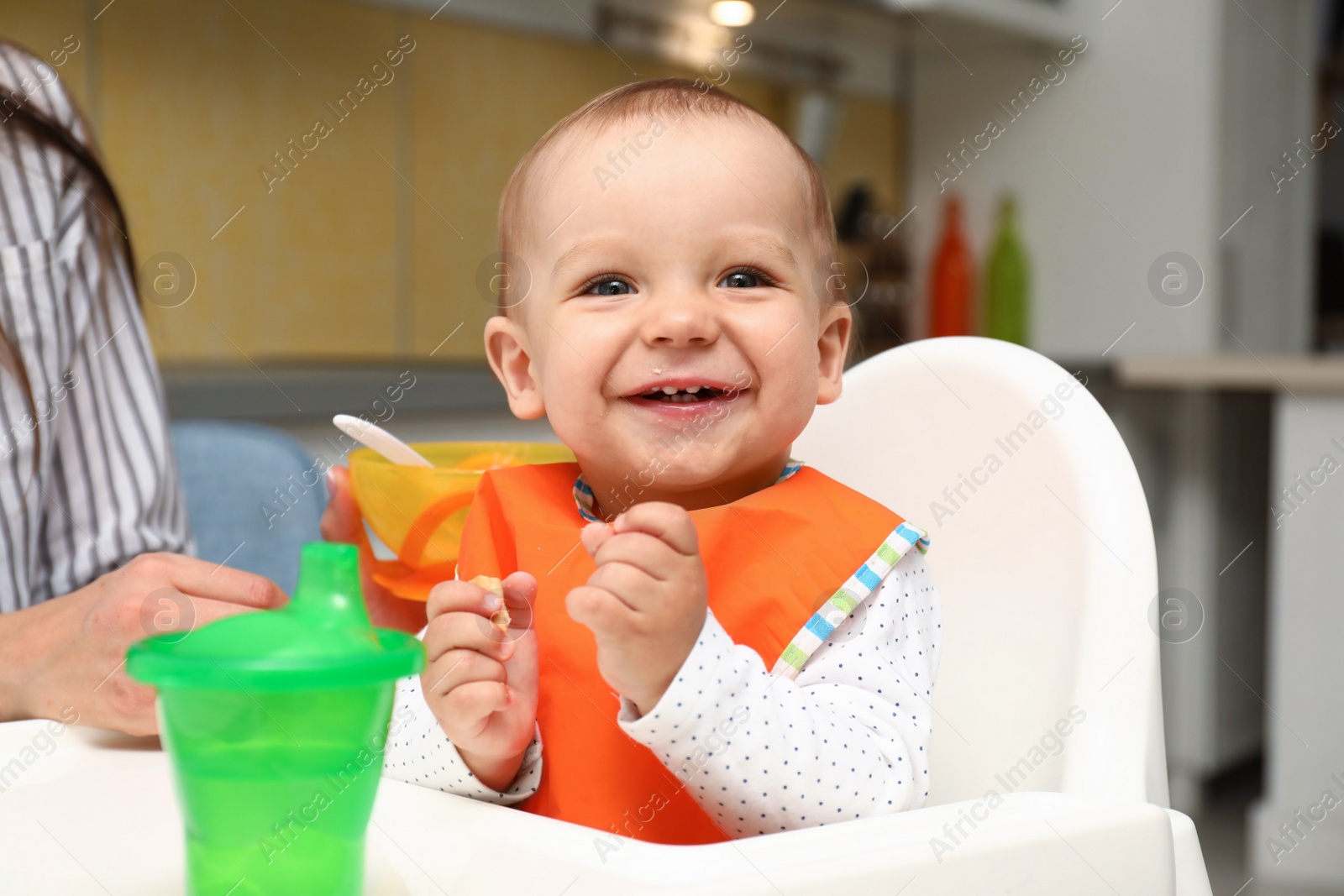 Photo of Young mother feeding her little baby at home