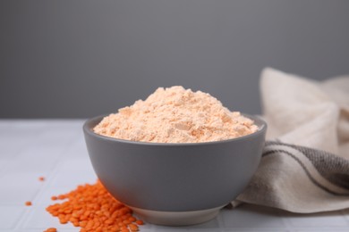 Bowl of lentil flour and seeds on white table