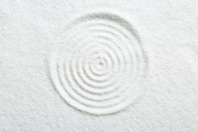 Photo of Zen rock garden. Circle pattern on white sand, top view