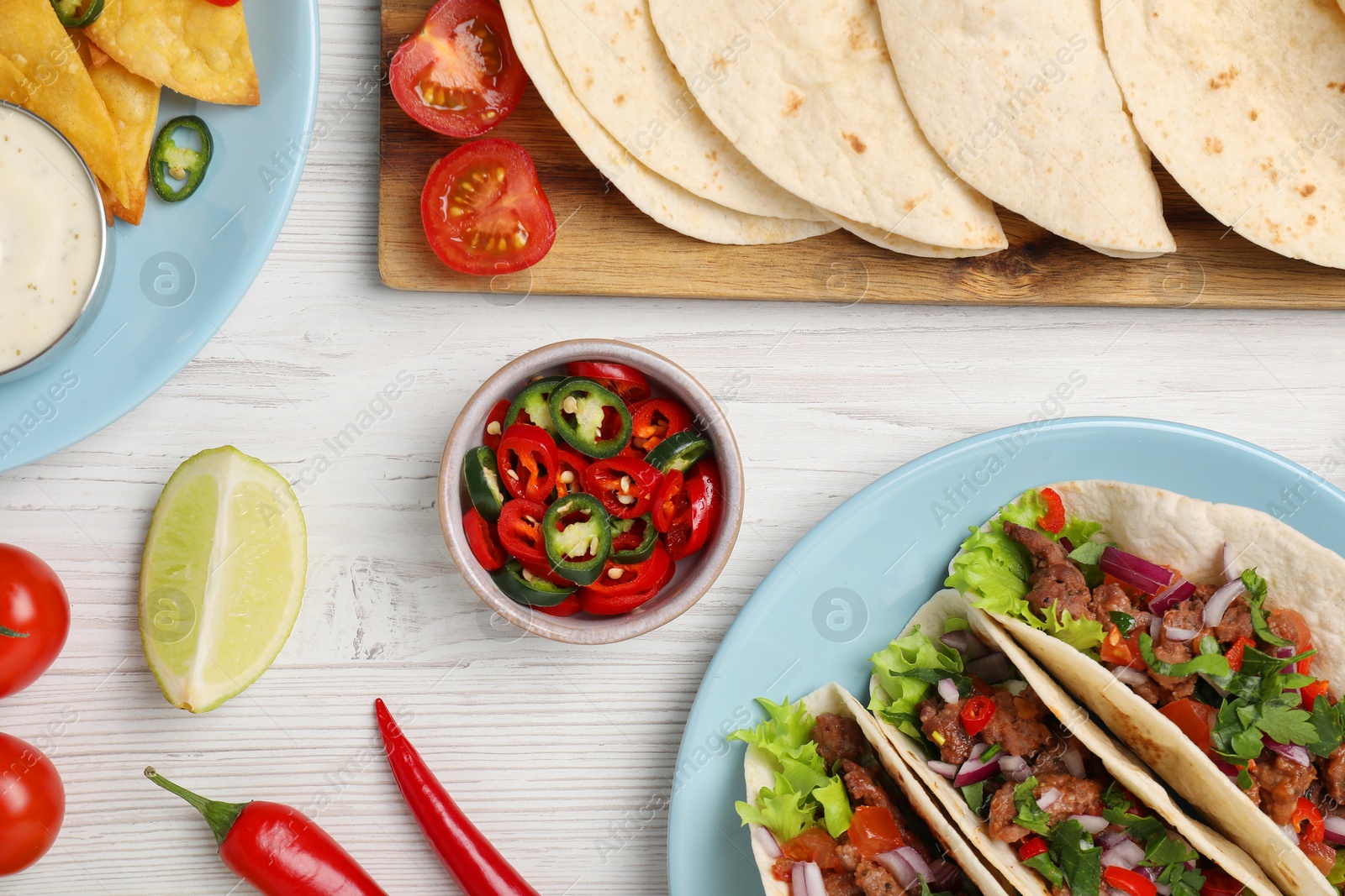 Photo of Flat lay composition with delicious tacos on wooden table